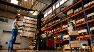 3pl warehouse workers using a forklift to lift a pallet of boxed
